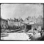 Mastenmakerswerf 'De Hoop' met op de achtergrond de gevels van Grote Bickersstraat 47-63. Foto: Jacob Olie 1862-1864. *Stadsarchief Amsterdam.)