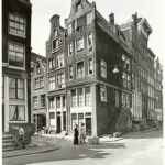 Links een gedeelte van Droogbak 17 - een man gaat juist de stoep op - met de Buiten Wieringenstraat in 1955. Foto: Stadsarchief Amsterdam.