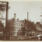 Vanuit het hoekpand (links, buiten beeld) keek men recht op de hoge schoorstenen van suikerraffinaderij De Granaatappel, hier in 1901. Foto: Masch Spakler, Hendrik van der. Stadsarchief Amsterdam