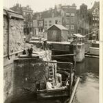 Reparatie aan de Haarlemmersluis met rechts Stroomarkt 1-9 (het hoekpand direct achter het houten huisje), ongedateerd. Bron: Stadsarchief Amsterdam