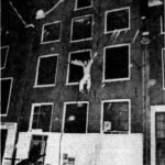 Een kraker brengt zich in veiligheid bij de brand in de panden aan de Nieuwezijds Voorburgwal en Sint Nicolaasstraat in 1974